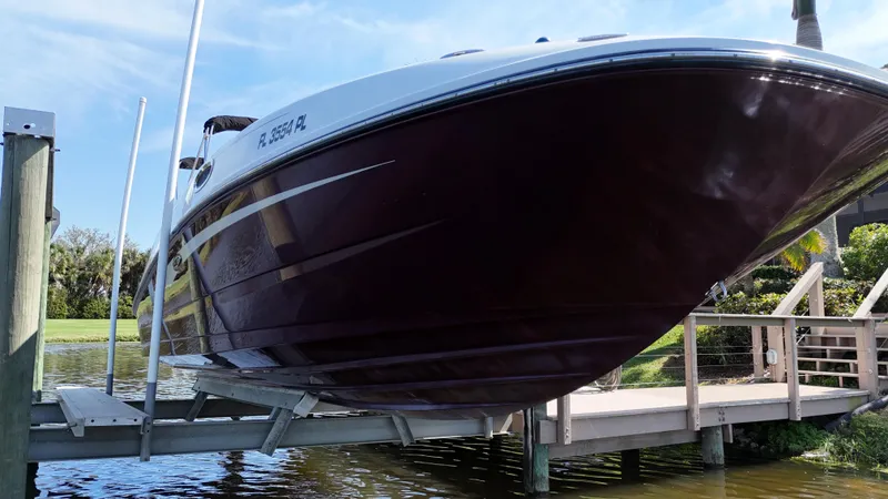 Slide: The Image of 2012 Sea Ray 280 Sundeck boat docked on a lift by the water. - 10