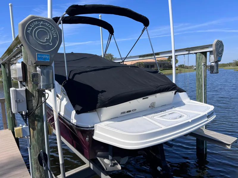 Slide: The Image of 2012 Sea Ray 280 Sundeck boat on lift, covered, near water. - 16