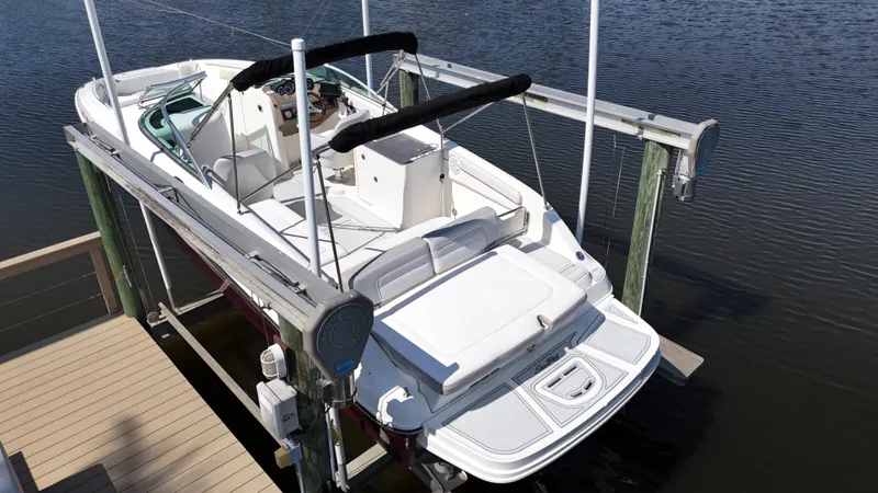 Slide: The Image of 2012 Sea Ray 280 Sundeck boat on lift, docked by calm water. - 2