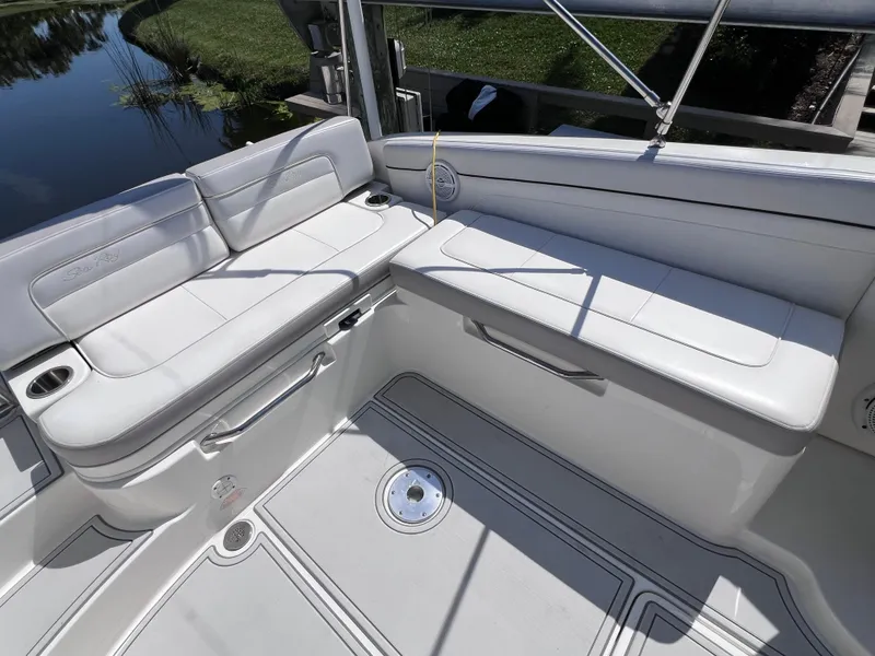 Slide: The Image of 2012 Sea Ray 280 Sundeck interior with white seating and cup holders. - 24