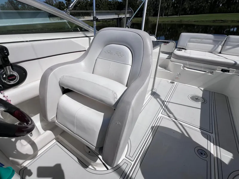 Slide: The Image of 2012 Sea Ray 280 Sundeck interior with white seating and steering wheel. - 29