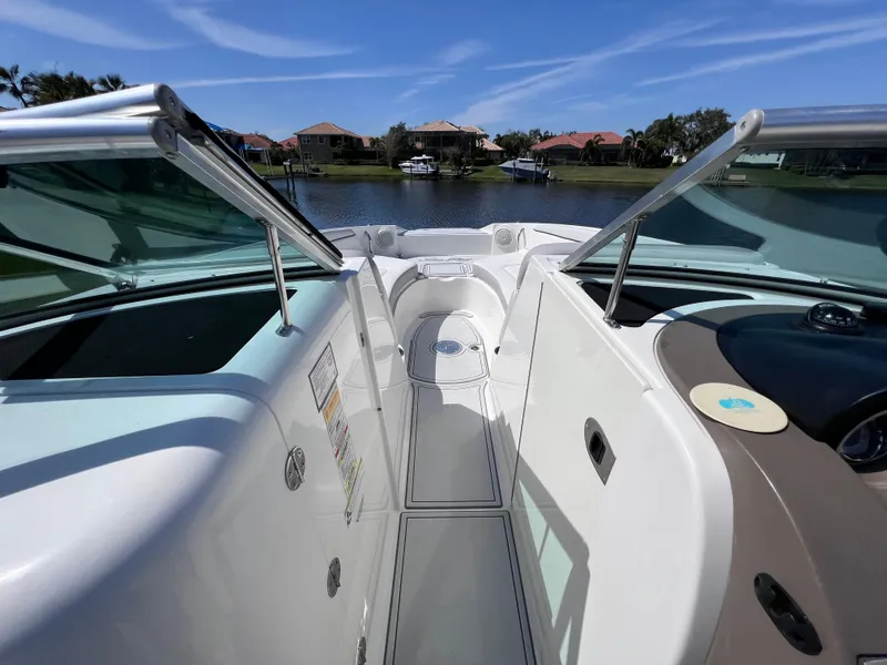 Slide: The Image of 2012 Sea Ray 280 Sundeck boat interior with open windshield, docked on a sunny day. - 47