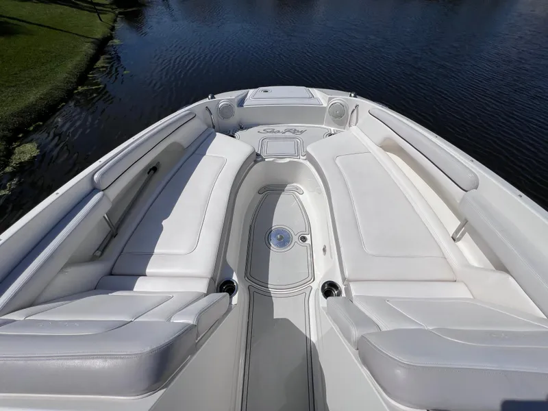 Slide: The Image of 2012 Sea Ray 280 Sundeck boat interior with white seating, on calm water. - 49