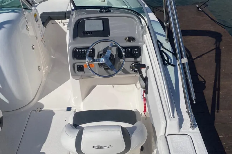 Slide: The Image of 2023 Robalo R207 Dual Console boat interior with steering wheel and dashboard. - 2