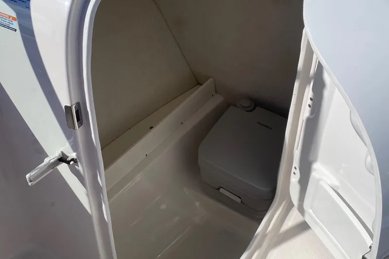 Slide: The Image of 2023 Robalo R207 Dual Console boat interior with compact marine toilet. - 4