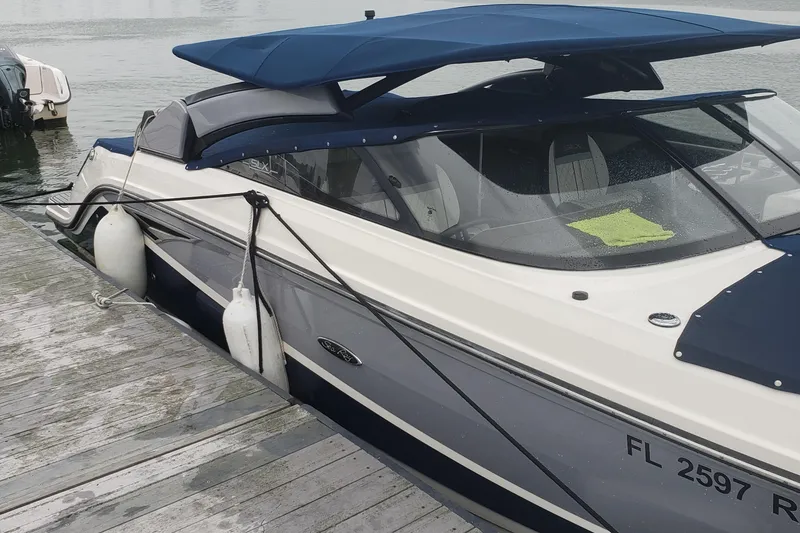 Slide: The Image of 2016 Sea Ray 280 SLX boat docked with blue canopy and fenders. - 10
