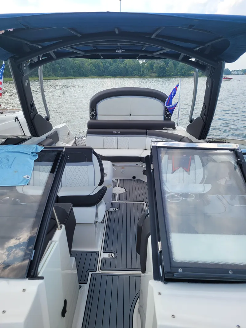 Slide: The Image of 2016 Sea Ray 280 SLX boat interior with seating and canopy on a lake. - 15