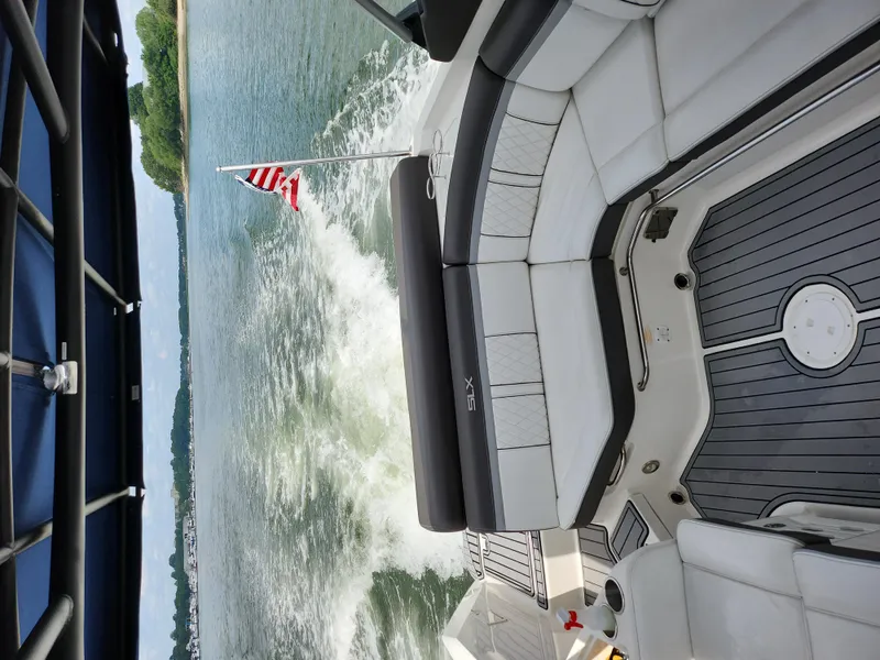 Slide: The Image of 2016 Sea Ray 280 SLX boat cruising on a lake with American flag. - 22