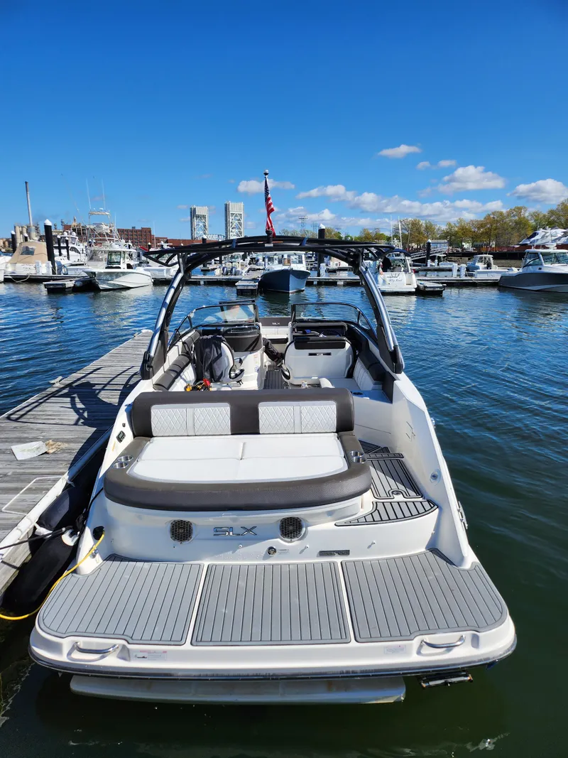 Slide: The Image of 2016 Sea Ray 280 SLX boat docked at marina under clear blue sky. - 25