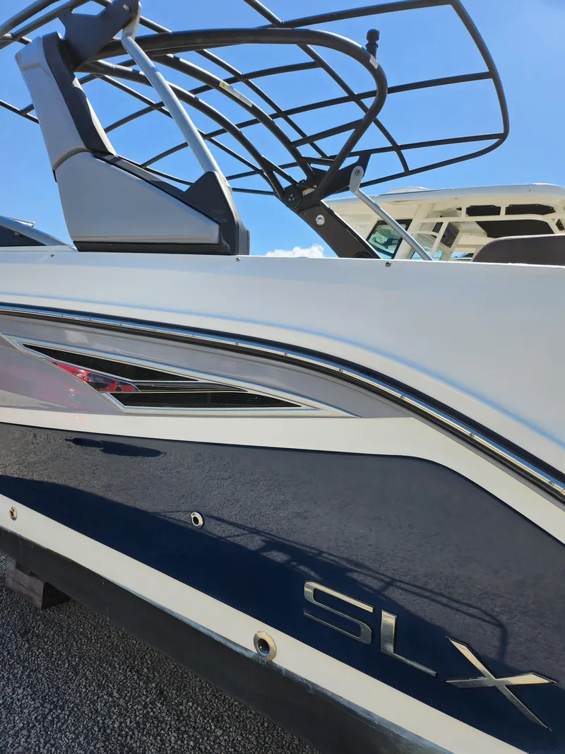 Slide: The Image of 2016 Sea Ray 280 SLX boat, sleek design, blue and white exterior, sunny day. - 26
