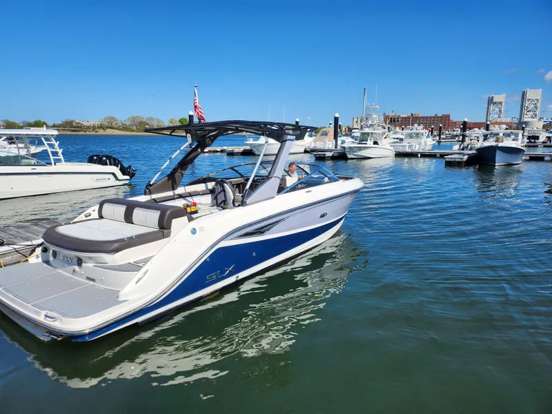 Slide: The Image of 2016 Sea Ray 280 SLX boat docked in a marina under clear blue skies. - 3