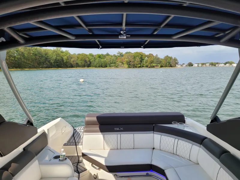 Slide: The Image of 2016 Sea Ray 280 SLX boat interior with lake view and lush greenery. - 30