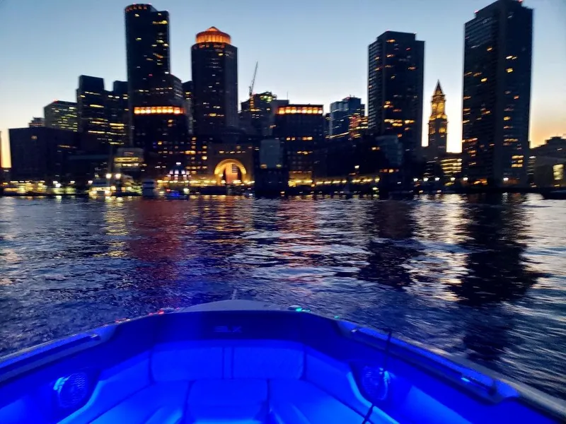 Slide: The Image of Sea Ray 280 SLX boat cruising at dusk with city skyline in the background. - 38