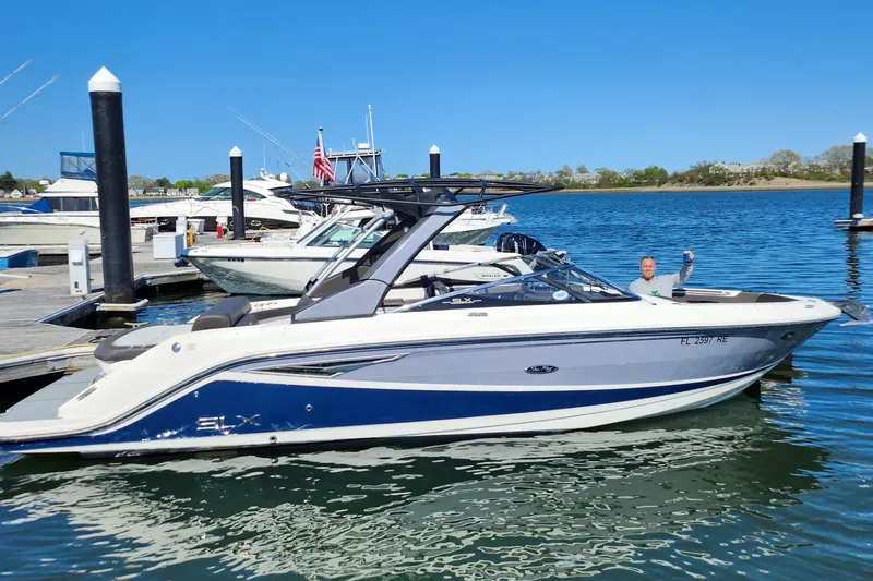 Slide: The Image of 2016 Sea Ray 280 SLX boat docked in a marina under clear blue skies. - 4