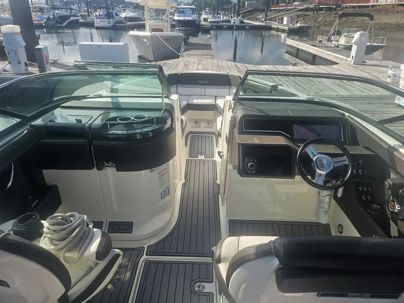 Slide: The Image of 2016 Sea Ray 280 SLX boat interior with steering wheel, seating, and dock view. - 45