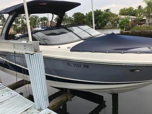Slide: The Image of 2016 Sea Ray 280 SLX boat docked, covered, with palm trees in the background. - 6