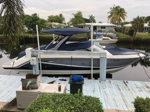 Slide: The Image of 2016 Sea Ray 280 SLX boat docked by a canal with lush greenery. - 7