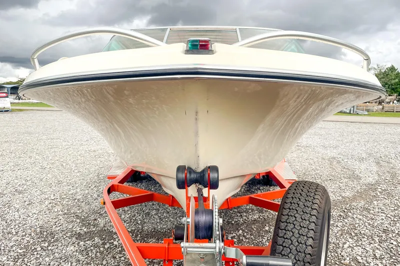 Slide: The Image of 1975 AristoCraft 19 boat on orange trailer, parked on gravel under cloudy sky. - 11