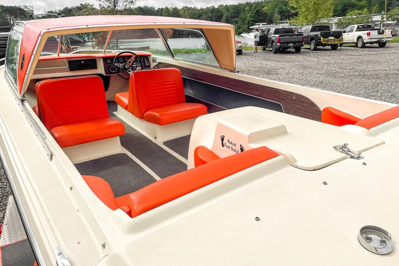 Slide: The Image of 1975 AristoCraft 19 boat with orange seats and open cockpit, parked outdoors. - 14