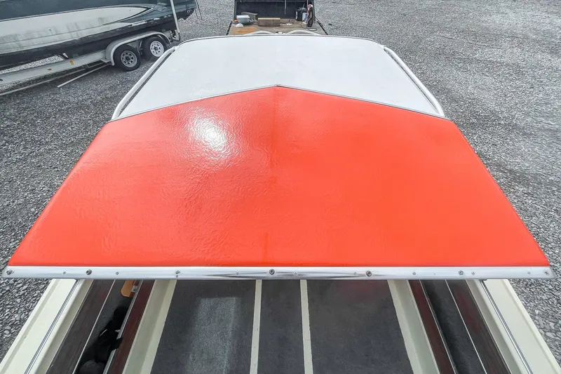 Slide: The Image of 1975 AristoCraft 19 boat with red and white deck, parked on gravel. - 31