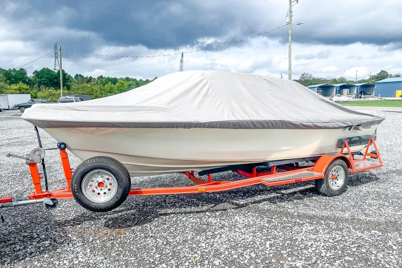 Slide: The Image of 1975 AristoCraft 19 boat on red trailer, covered, parked on gravel lot. - 8