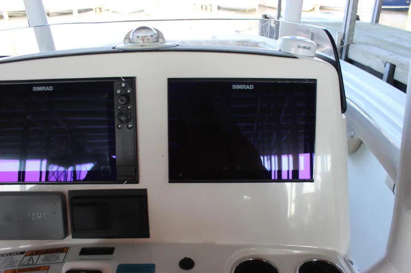 Slide: The Image of 2018 NauticStar 28 XS Offshore boat dashboard with dual Simrad displays. - 17