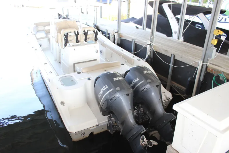 Slide: The Image of 2018 NauticStar 28 XS Offshore boat with dual Yamaha engines docked. - 2