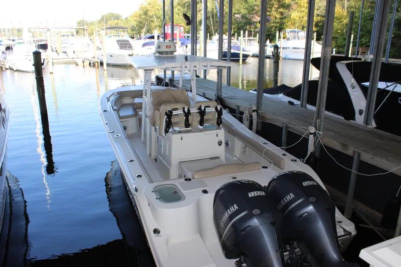 Slide: The Image of 2018 NauticStar 28 XS Offshore boat docked with twin Yamaha engines. - 3