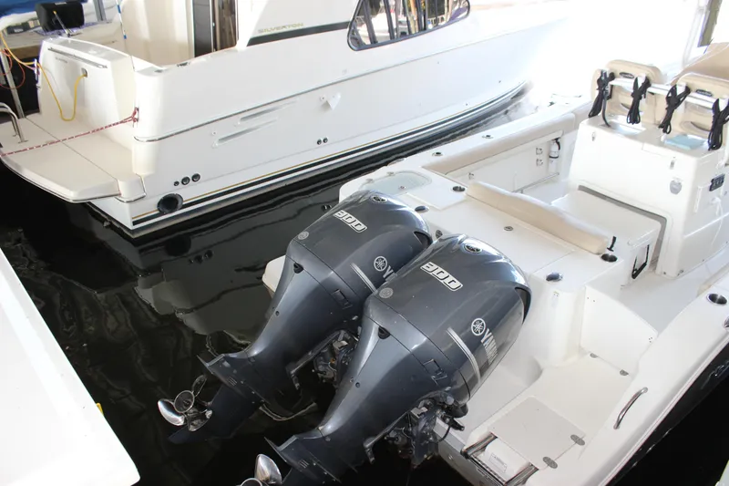 Slide: The Image of 2018 NauticStar 28 XS Offshore boat with dual outboard engines docked. - 5
