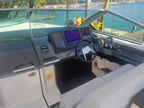 Slide: The Image of 2022 Aviara AV32 OB boat cockpit with modern controls and waterfront view. - 18