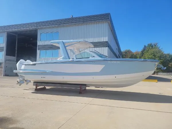 Slide: The Image of 2022 Aviara AV32 OB boat displayed outdoors near a large warehouse. - 35