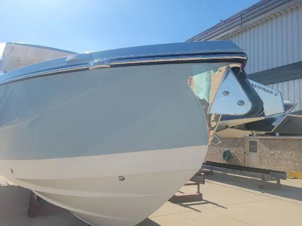 Slide: The Image of 2022 Aviara AV32 OB boat, sleek design, docked outdoors under clear blue sky. - 37