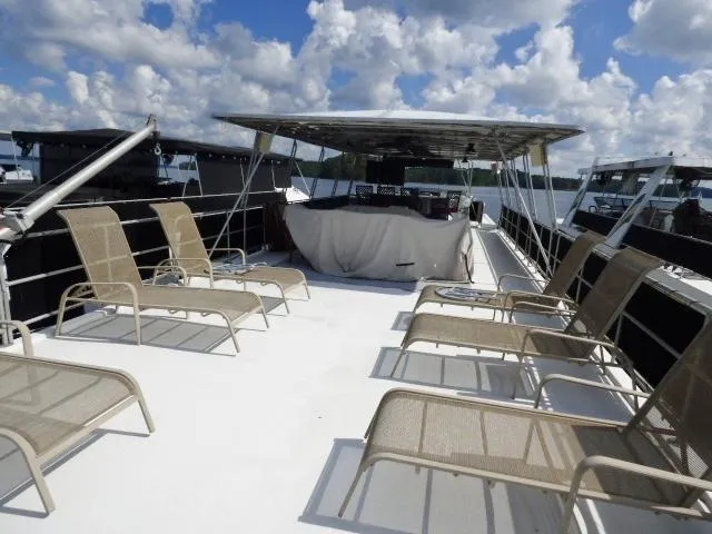 Slide: The Image of 1997 Sumerset 16x80 houseboat deck with lounge chairs under a blue sky. - 13