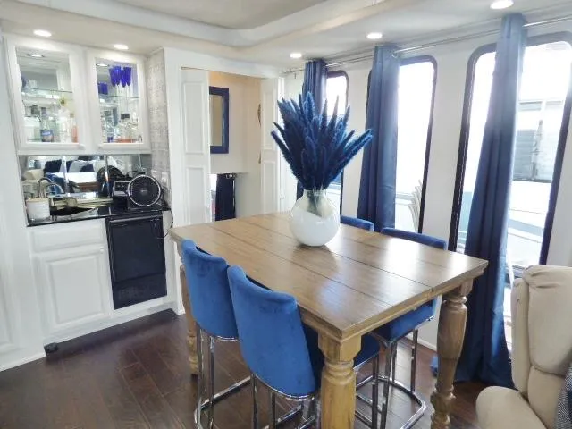 Slide: The Image of 1997 Sumerset 16x80 houseboat interior with dining area, blue chairs, and modern decor. - 5