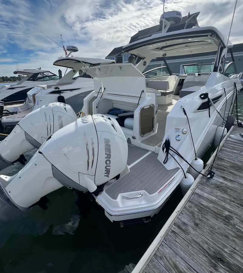 Slide: The Image of 2022 Sea Ray Sundancer 320 OB with dual Mercury outboard engines docked at marina. - 11