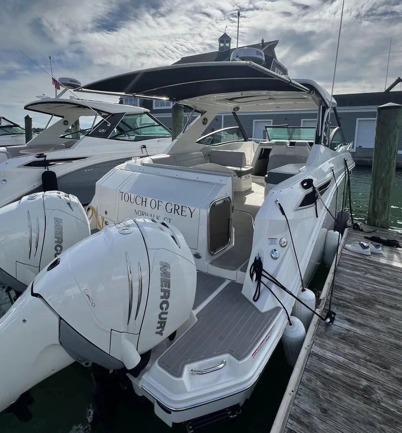 Slide: The Image of 2022 Sea Ray Sundancer 320 OB docked, featuring dual Mercury outboard engines. - 12