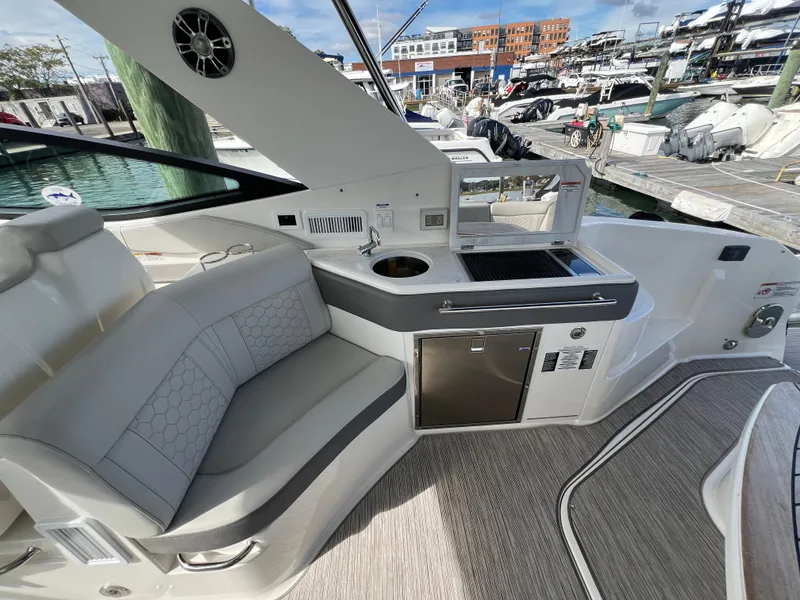 Slide: The Image of 2022 Sea Ray Sundancer 320 OB interior with seating and kitchenette at marina. - 20