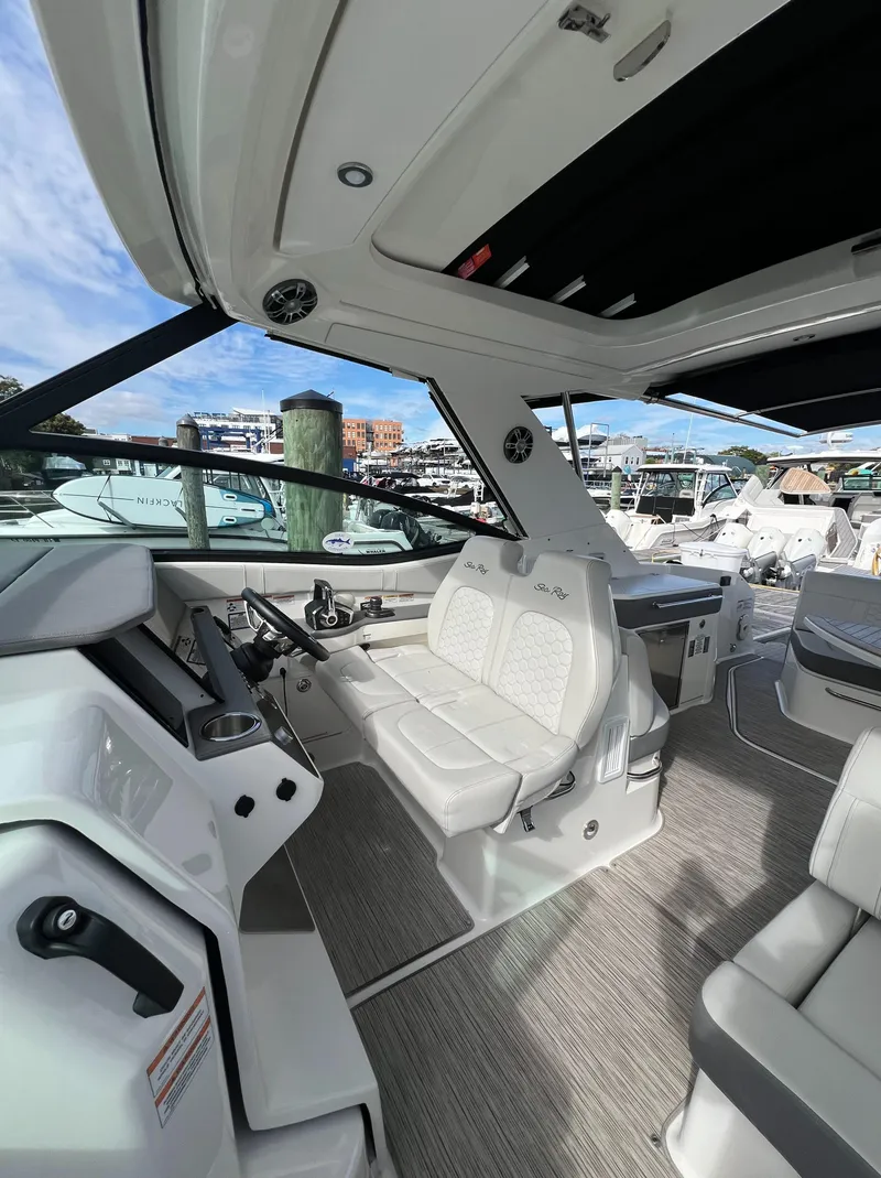 Slide: The Image of 2022 Sea Ray Sundancer 320 OB interior with modern seating and dashboard, docked at marina. - 32