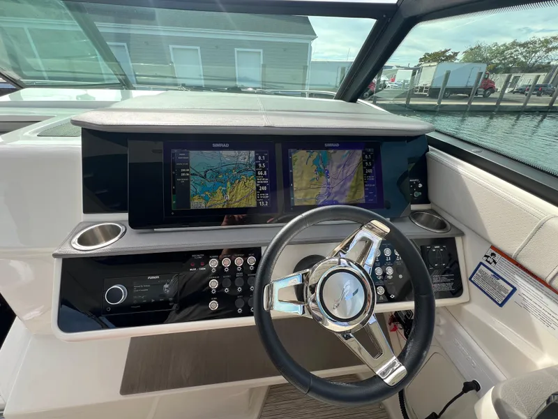 Slide: The Image of 2022 Sea Ray Sundancer 320 OB helm with dual navigation screens and modern controls. - 36