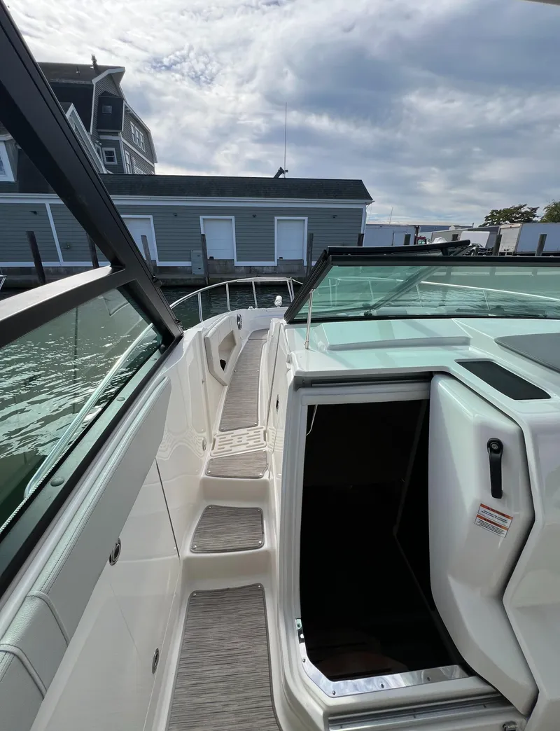 Slide: The Image of 2022 Sea Ray Sundancer 320 OB, sleek design, docked by waterfront buildings. - 39