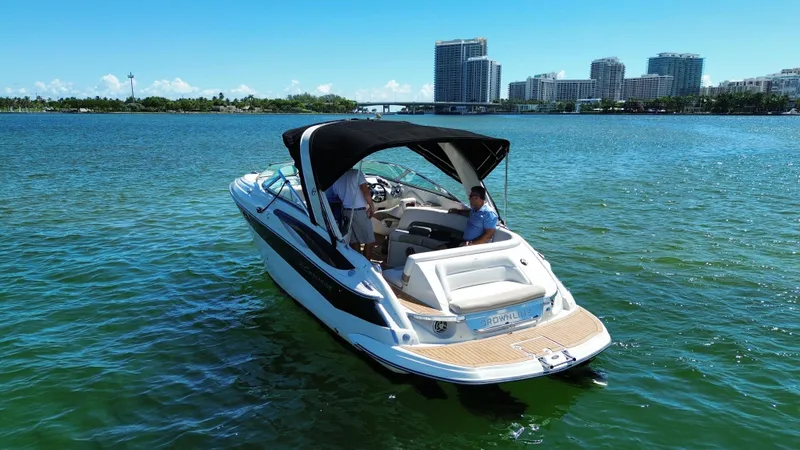 Slide: The Image of 2008 Crownline 300 LS boat cruising on a sunny day near city skyline. - 2