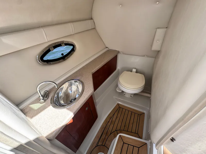 Slide: The Image of 2008 Crownline 300 LS boat bathroom with sink, toilet, and wood flooring. - 28