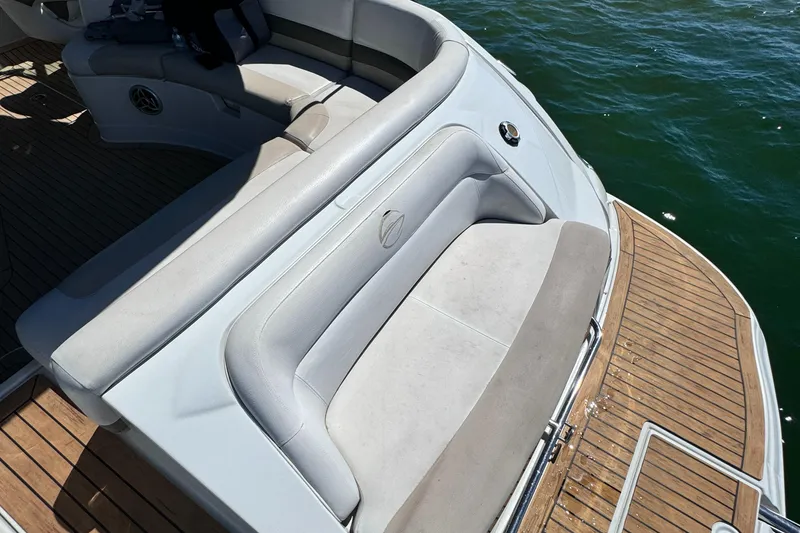 Slide: The Image of 2008 Crownline 300 LS boat with cushioned seating and wooden deck by the water. - 35