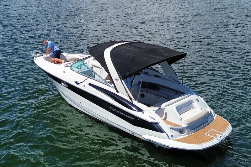 Slide: The Image of 2008 Crownline 300 LS boat on water with black canopy and wooden deck. - 4