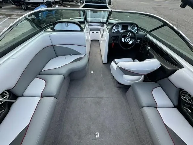 Slide: The Image of 2011 Supra 22v boat interior with gray and white seating, modern dashboard, and spacious layout. - 11