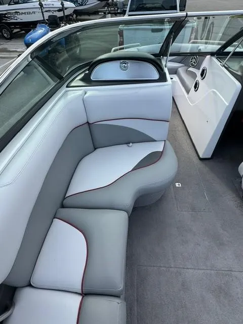 Slide: The Image of 2011 Supra 22v boat interior with gray and white seating, red accents. - 12