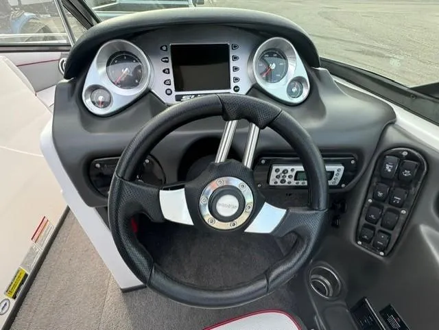 Slide: The Image of 2011 Supra 22v boat dashboard with steering wheel and control panel. - 14