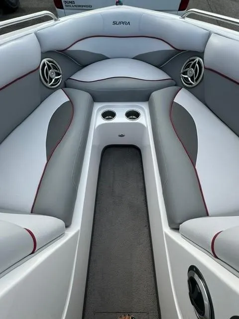 Slide: The Image of 2011 Supra 22v boat interior with gray and white seating, cup holders, and speakers. - 17