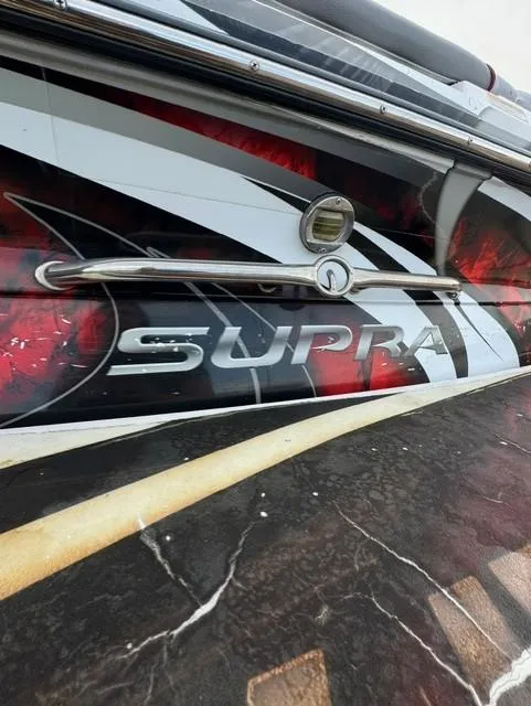 Slide: The Image of 2011 Supra 22v boat with bold graphics and logo detail. - 21
