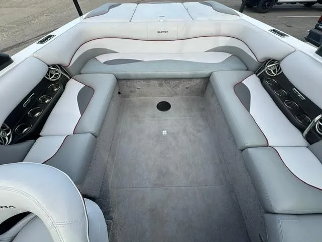 Slide: The Image of 2011 Supra 22v boat interior with gray and white seating, cup holders, and spacious layout. - 8